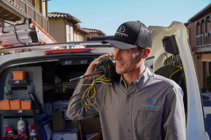 Two Cloud Comfort HVAC technicians pressure-testing an outdoor gas line together