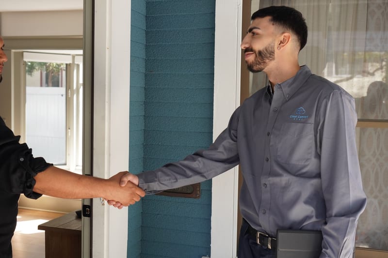 Cloud Comfort HVAC technician shaking hands with a homeowner at the front door